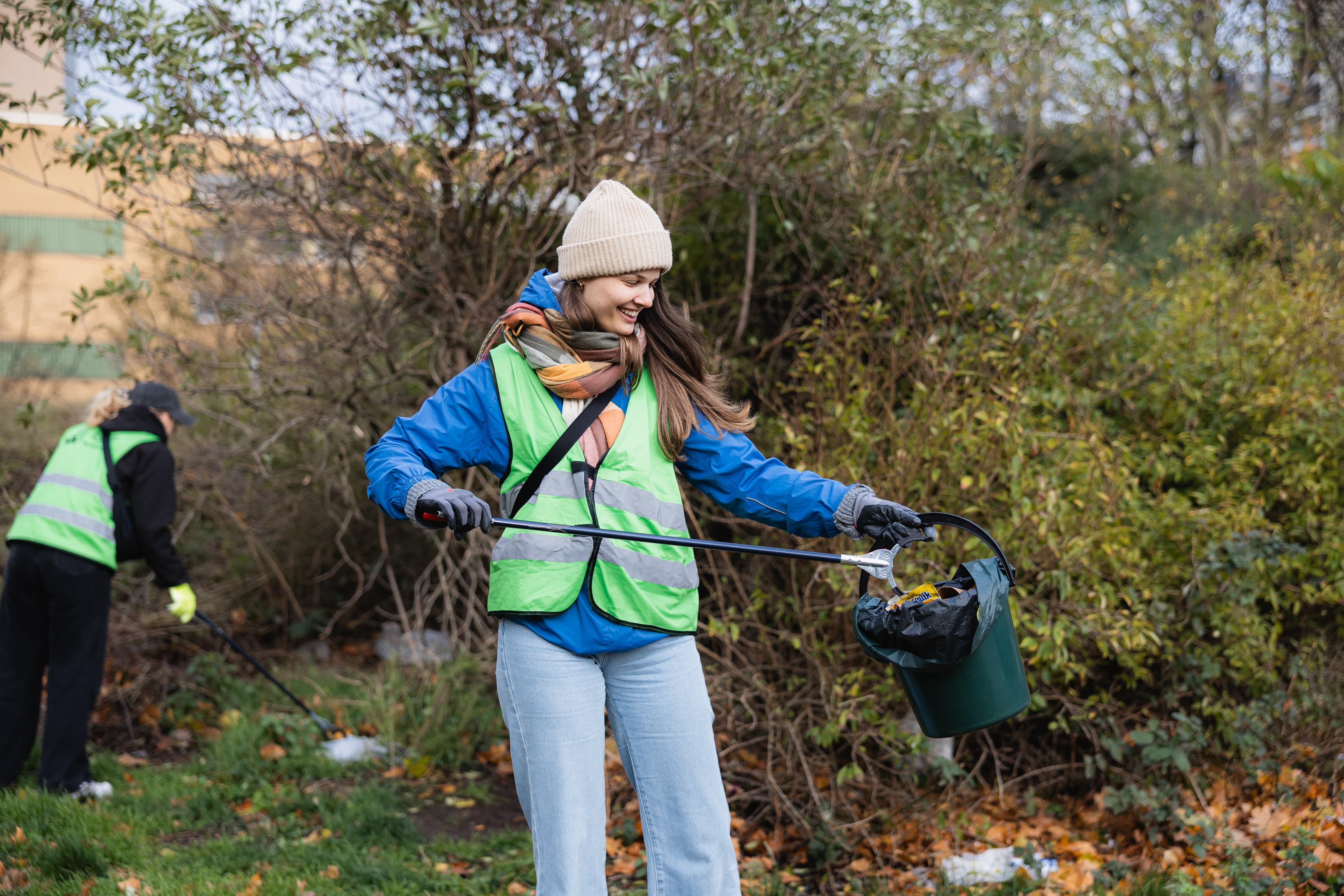 Eine Frau sammelt Müll auf