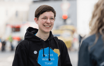 Interviewsituation mit der Mitarbeiterin Luisa, die einen schwarzen WERTGARANTIE Hoodie trägt.