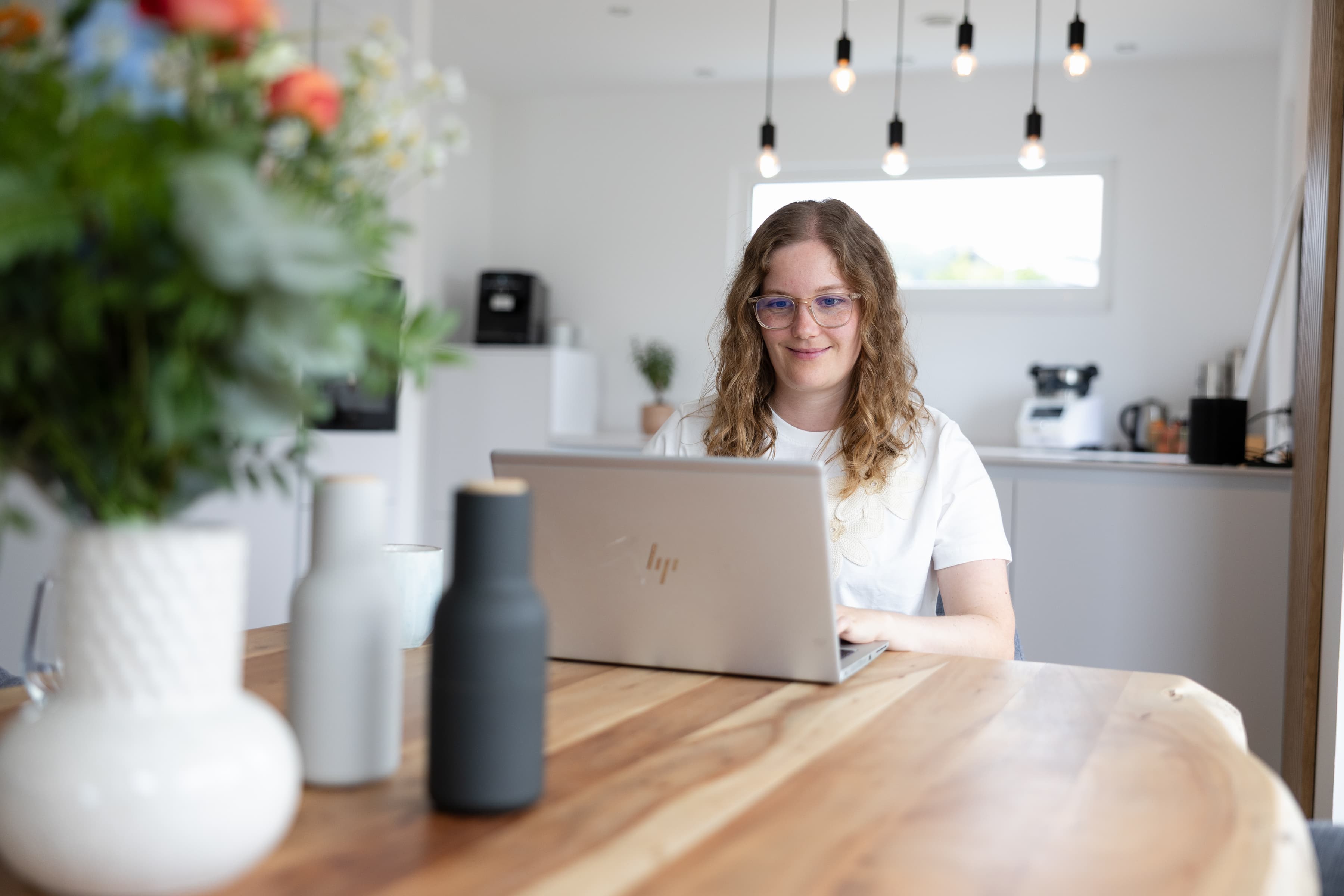 Katharina sitzt am Tisch vor einem Laptop