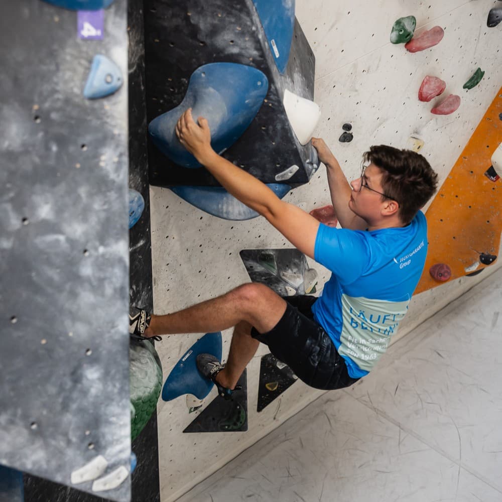 Ein Mann klettert an einer Boulderwand