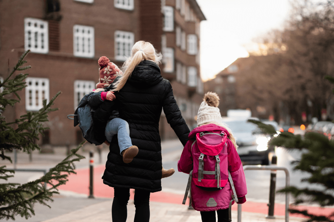 Sabrina Rust, Teamleiterin Kunden-Qualitätsmanagement, mit ihrer Tochter auf dem Arm und der anderen Tochter an der Hand auf dem Weg zum Kindergarten.