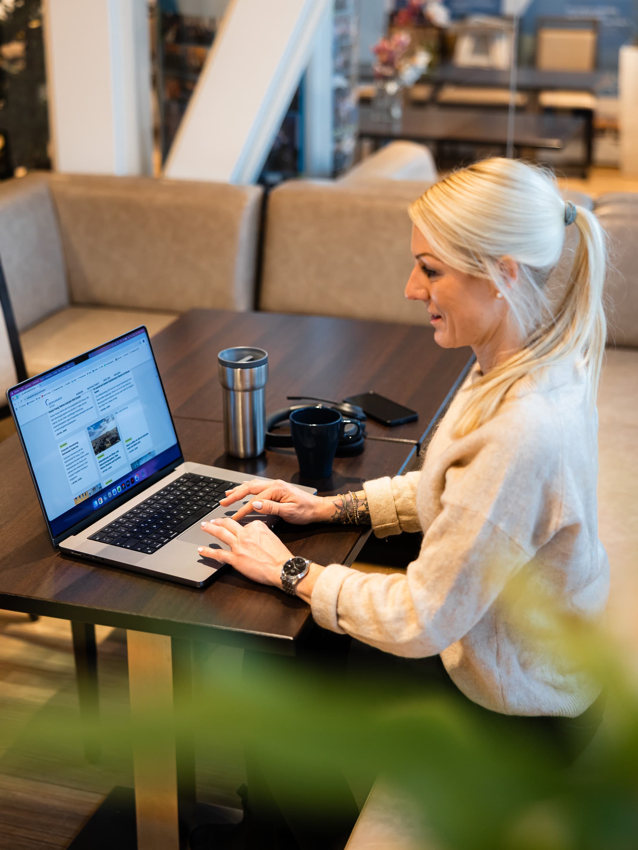 Teamleiterin Sabrina Rust sitzt im Bistro und arbeitet an ihrem Laptop.